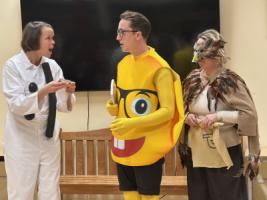 An actor in a :) costume faces two more actors, who are dressed in a Glasses-emoji costume and as a hawk